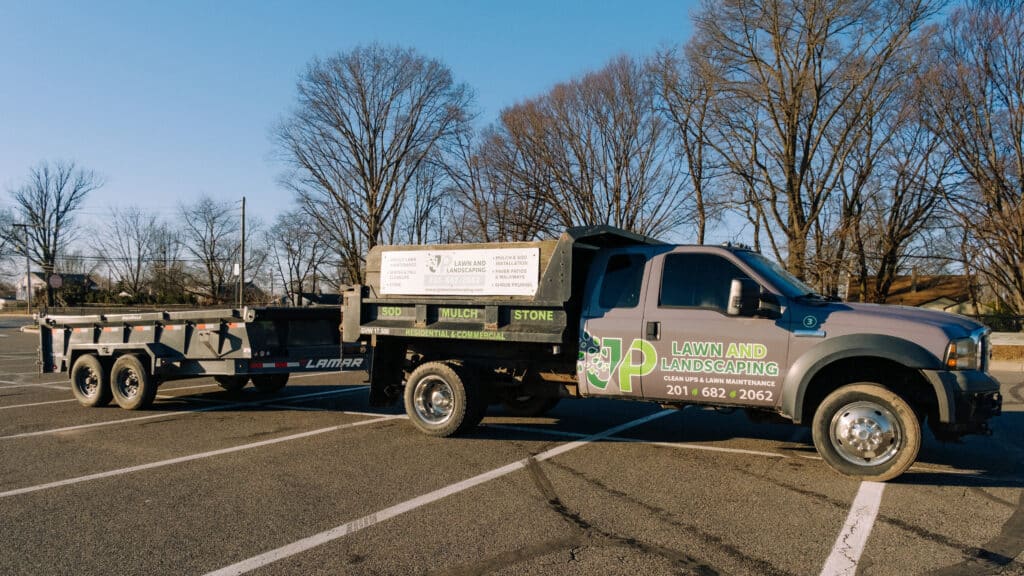 JP Lawn and Landscaping branded work truck and dump trailer offering lawn maintenance, mulch, sod, and paver services in Burlington County NJ