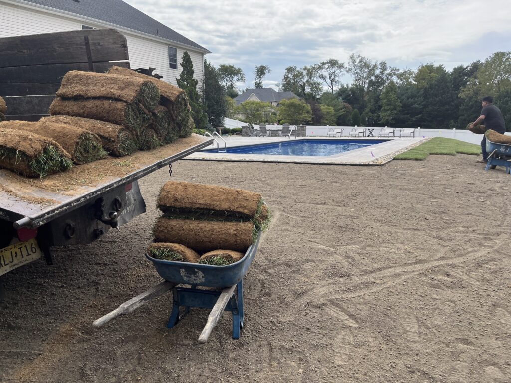 Sod rolls being delivered by truck for poolside lawn installation in Burlington County NJ
