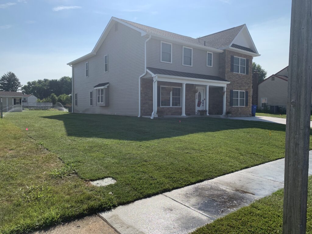 Stone facade house front yard after sod installation street view in New Jersey